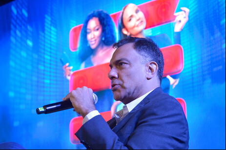 Fabio Avellar, VP da TIM, com imagem de Iza e Ivete ao fundo