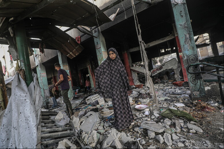Mulher caminha em meio a destroços deixados por bombardeio na Cidade de Gaza - TODOS OS DIREITOS RESERVADOS